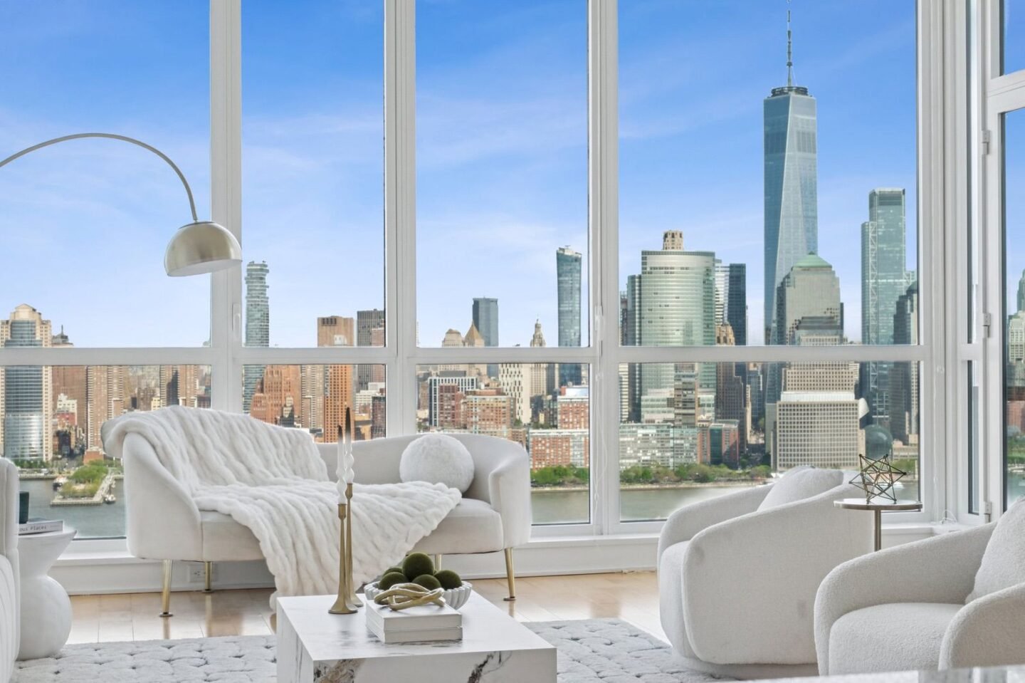 Bright furnished condo living room with a Manhattan skyline view